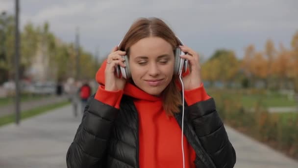 Europeiska kvinnan tar av hörlurarna efter att ha lyssnat på musik — Stockvideo