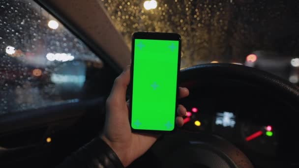 POV, mão masculina segurando smartphone com tela verde em um carro à noite — Vídeo de Stock