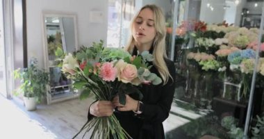Çiçekçi kadın bir buket çiçek yapar.