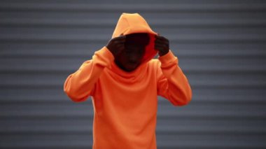 Yakışıklı ve havalı Afrikalı adam parlak turuncu kapüşonlu