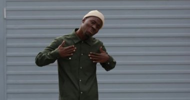 Yakışıklı, karizmatik, şık kıyafetler ve şapka giyen Afrikalı bir adam.
