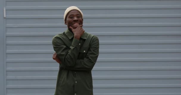 Gelukkig Afrikaans man draagt kleding lachen in de buurt muur — Stockvideo