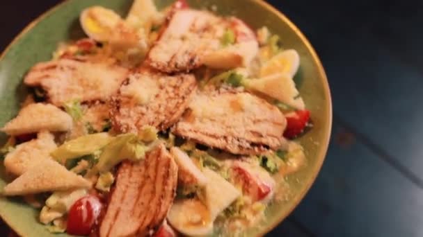 Macro video van vrouw zet Caesar salade op een tafel — Stockvideo