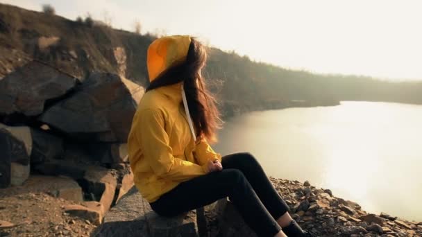 Mujer excursionista mirando el atardecer cerca del lago — Vídeos de Stock