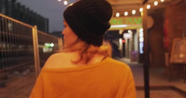 Ung fashionabel kvinna går i urban stad bär tröja och hatt — Stockvideo