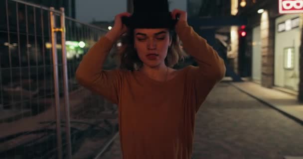 Genç, şık bir kadın, şehir merkezinde şapka takıyor. — Stok video