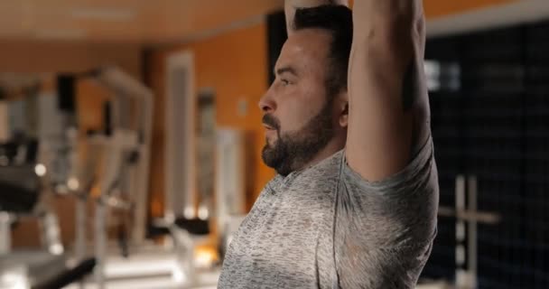 Hombre levantando pesas en un gimnasio haciendo ejercicio para deltoides — Vídeos de Stock