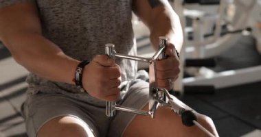 Spor salonunda egzersiz yapan bir adam kaslarını güçlendirir.