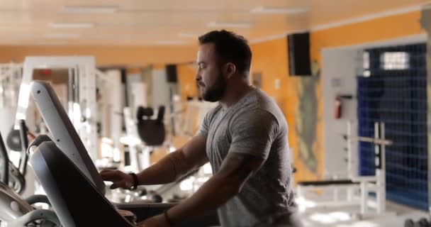 Homme courant sur un tapis roulant dans la salle de gym — Video
