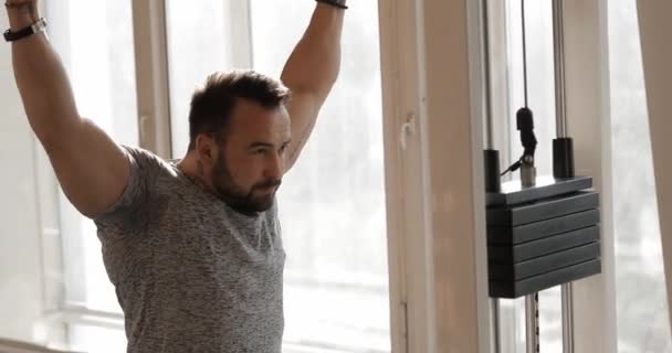 Homem se exercitando em um ginásio tornando seus músculos mais fortes — Vídeo de Stock
