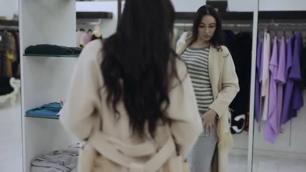 Femme acheteur essayer manteau de fourrure beige dans la boutique — Video