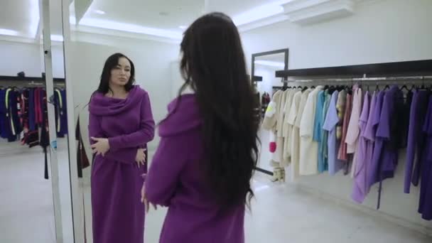 Woman buyer try on violet fur coat in the boutique — Stockvideo