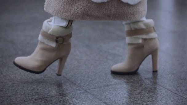 Женщина идет в зимних каблуках, ботинки крупным планом — стоковое видео
