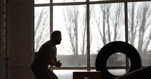 Homme faisant de l'exercice dans une salle de gym sautant sur une boîte — Video
