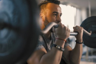 Ez bar vaiz kıvrımlı, pazı egzersizi yapan bir adam.