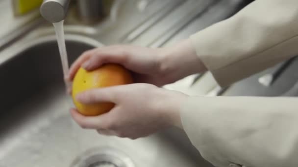 Frauenhände waschen Grapefruit in der Spüle — Stockvideo