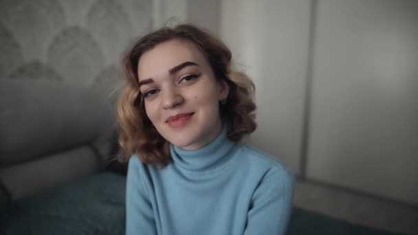 Mooie kokette vrouw kijken naar camera in huis en likt haar lippen — Stockvideo