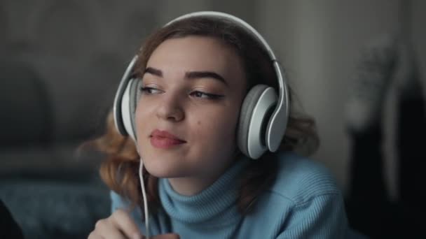 Mujer escuchando música en casa con auriculares grandes — Vídeos de Stock