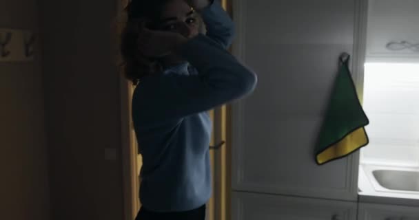 Ung lycklig kvinna dansar på sitt kök på natten — Stockvideo