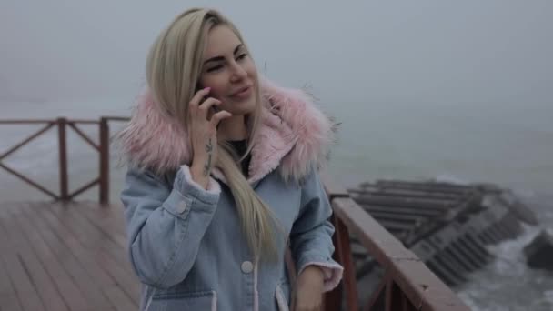 Vrouw praten met mobiele telefoon in de buurt van de oceaan, slowmotion — Stockvideo