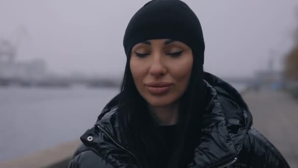 Стильна жінка, що йде біля берега річки взимку — стокове відео