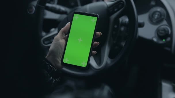 Γυναικεία χέρι κρατώντας κενό οθόνη του smartphone σε ένα αυτοκίνητο — Αρχείο Βίντεο