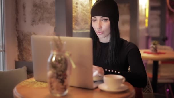 Mujer blogger freelancer con estilo trabajando por computadora portátil en la cafetería — Vídeo de stock
