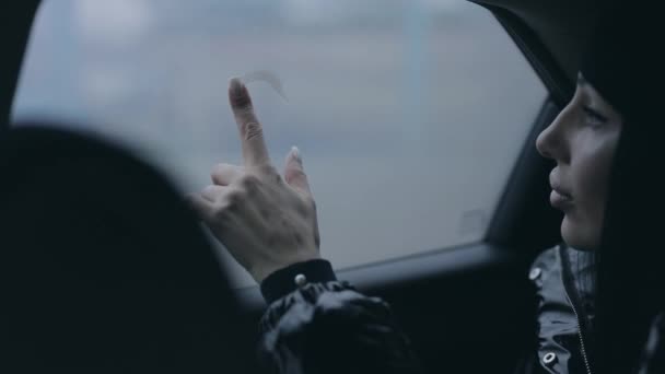 Vrouw tekening hart op een natte auto venster — Stockvideo
