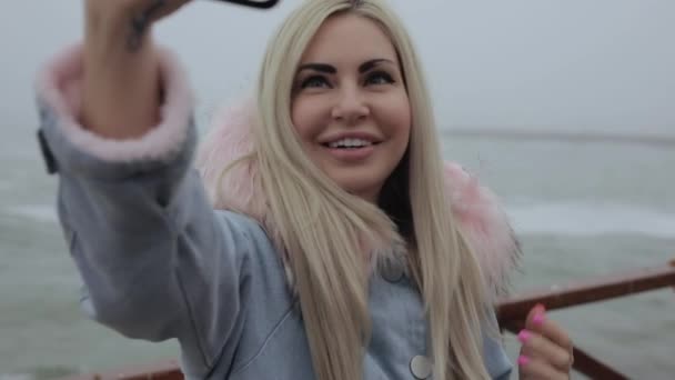 Woman taking selfie with mobile phone near sea — Stock Video