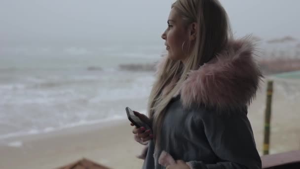 Nő használ mobiltelefon tenger közelében, lassított mozgás — Stock videók