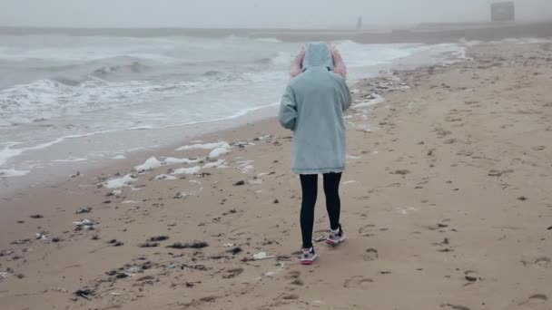 Donna che cammina sulla costa oceanica godendo della libertà della natura — Video Stock