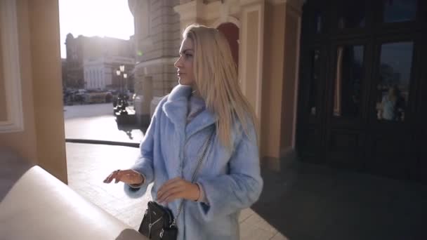 Красива блондинка насолоджується зимовим днем, стоячи в палаці — стокове відео