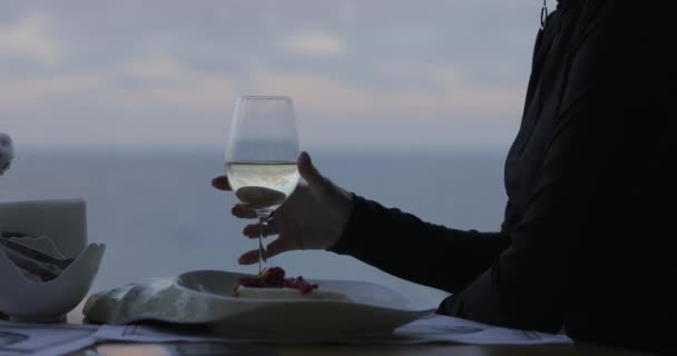 Vrouw drinkt witte wijn in restaurant met uitzicht op zee — Stockvideo