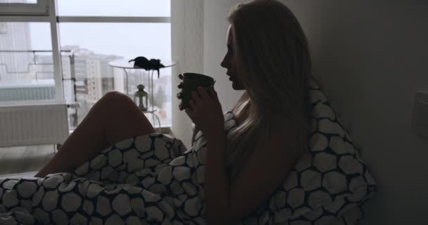 Donna che beve tè nel letto al mattino — Video Stock