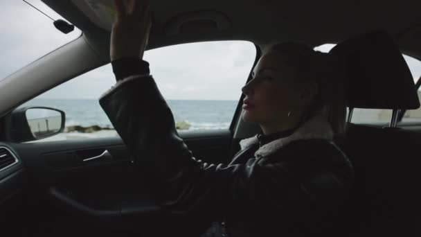 Vrouw passagier bewondert zichzelf in de spiegel zitten in de auto — Stockvideo