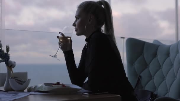Mujer bebiendo vino blanco en restaurante con vista al mar — Vídeos de Stock
