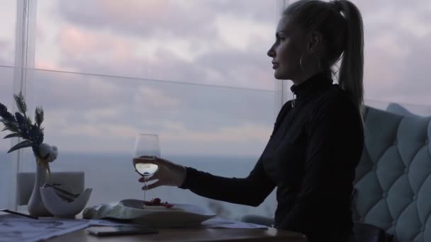 Mujer bebiendo vino blanco en restaurante con vista al mar — Vídeo de stock
