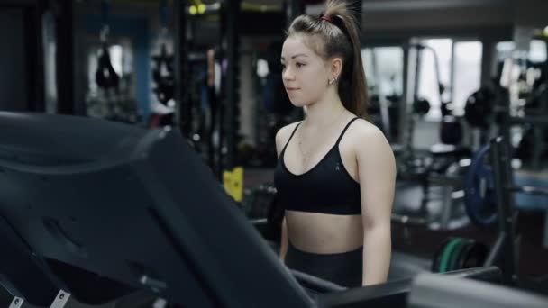 Fiatal nő megy a futópadon — Stock videók