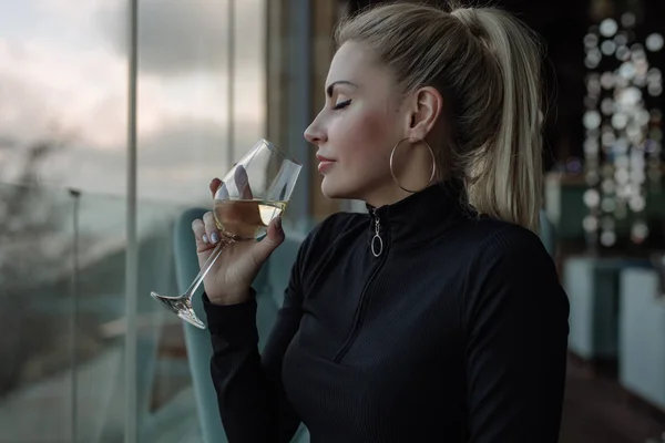 Lyxig kvinna dricker vitt vin på restaurang med havsutsikt — Stockfoto