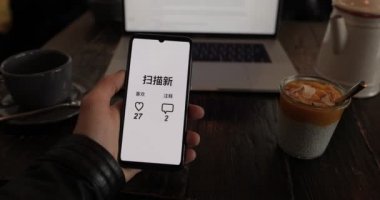 Yeni beğeni ve yorumları tarayan uygulamalı akıllı telefon tutan erkek.