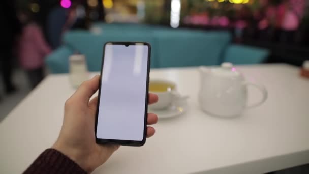 Тримає смартфон із додатком, який сканує нові вподобання — стокове відео