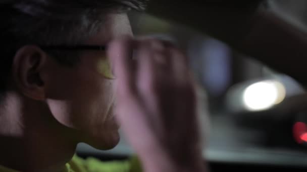 Närbild av man förare bär gula glasögon på natten — Stockvideo