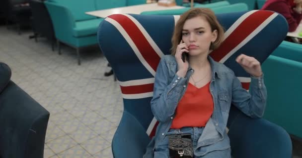 Sluwe vrouw zitten in cafe praten per telefoon — Stockvideo