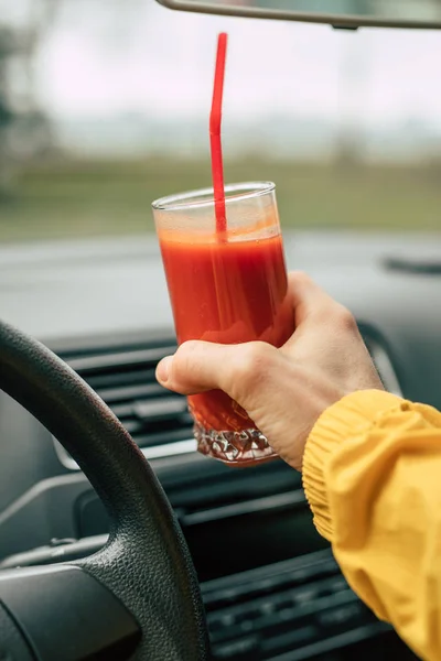 Mies kuljettaja tilalla tomaattimehua autossa — kuvapankkivalokuva