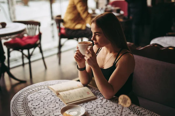 ผู้หญิงสาวดื่มกาแฟในคาเฟ่ — ภาพถ่ายสต็อก