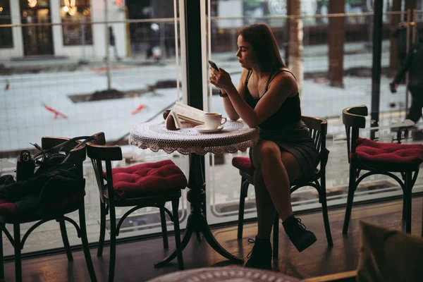 Frau spielt im Café mit Smartphone — Stockfoto