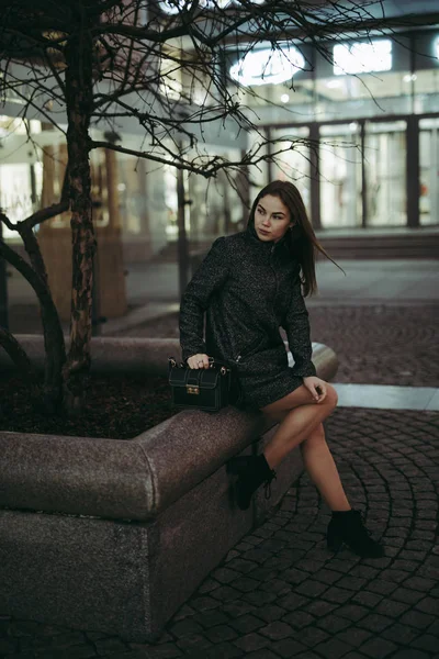 Mulher de moda sentado na cidade da noite — Fotografia de Stock