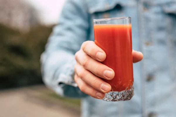 Tomato juice in a male hand — 스톡 사진