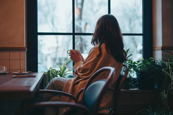 Неузнаваемая женщина мечтает, глядя в окно в кафе — стоковое фото