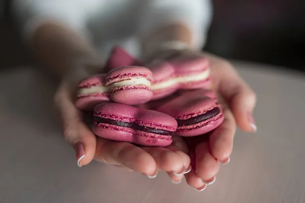 Manos de mujer sosteniendo muchos macarrones en forma de corazón —  Fotos de Stock